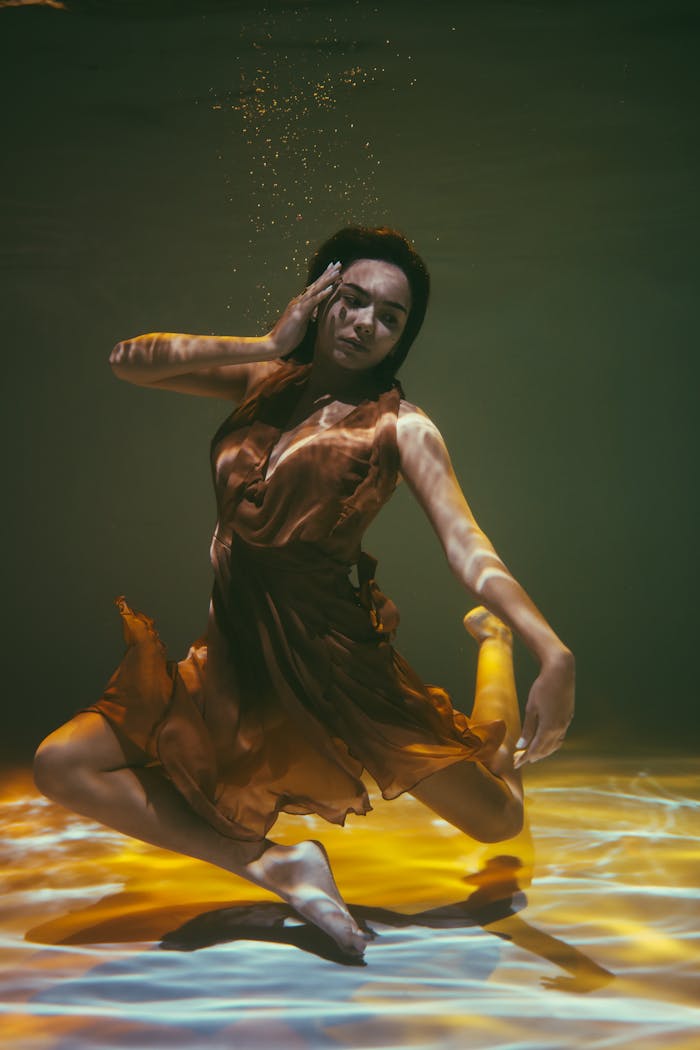 why-choose-us A woman performs a graceful underwater dance, enveloped in artistic lighting and serene ambiance.