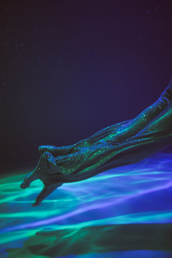 hero-img-01 Mystical underwater shot capturing fabrics graceful flow with vibrant lighting effects.